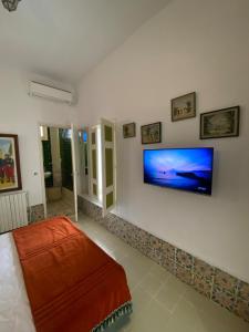 ein Wohnzimmer mit einem Flachbildfernseher an der Wand in der Unterkunft la terrasse aux souvenirs in Karthago