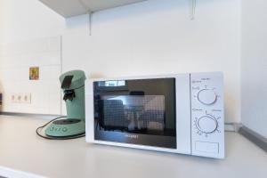 a microwave on a counter next to a blender at Ferienwohnungen am Gellershagenpark 2 in Braksiek