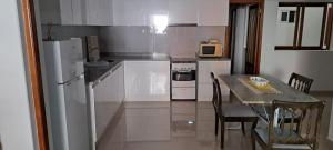 Ribeira GrandeCasa Flor Apartment的厨房里有一张桌子和一台白色冰箱