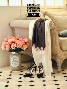 Un vestido y zapatos en una silla con un jarrón de flores. en LES ANGES DELUXE AVIGNON - Exclusive Romantic Home - Private Luxury Tours, en Aviñón