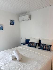 a white bedroom with a white bed with pillows at Tika Bungalow - Pisicne, Wifi, Grande Terrasse privée et Accès Plage à pied in Grand-Bourg +21 photos