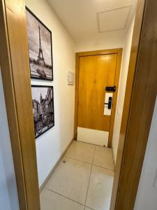 Un pasillo con una puerta y una imagen de la Torre Eiffel. en Studio Luxury - piscina e ar condicionado, en Río de Janeiro 54 fotos más