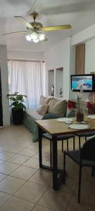 una sala de estar con un sofá y una mesa en Caelum House Apartamento, en Rafaela