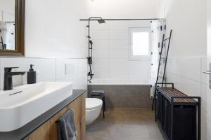 a white bathroom with a sink and a toilet at Chuenislodge2- zwei Balkone, gemütlicher Kamin, top Aussicht in Adelboden +45 photos