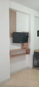 TV colgada en la pared de una habitación en Caelum House Apartamento, en Rafaela