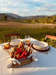 un tavolo da picnic con un cesto di cibo e bicchieri di vino di Villa FARFA a Castelnuovo di Farfa
