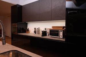 una cucina con un bancone con un microonde sopra di Villa FARFA a Castelnuovo di Farfa Altre 20 foto