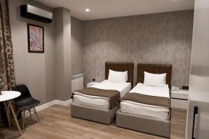 a bedroom with two beds and a table and a chair at Old Baku Boutique Hotel in Baku