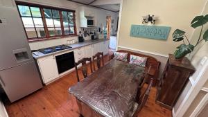 eine Küche mit einem Tisch mit Stühlen und einer Arbeitsplatte in der Unterkunft Cabin & Cottage Kaapsehoop in Kaapsehoop