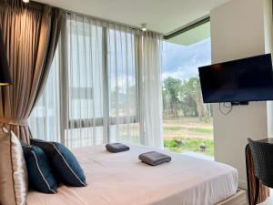 une chambre avec un lit avec une grande fenêtre dans l'établissement Oceanstone by RESAVA, à Bang Tao Beach