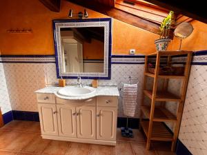 une salle de bain avec un lavabo et un miroir dans l'établissement BILBO Near ático rural con terraza, à Basauri 36 autres photos