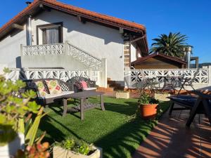 un patio avec une table et des chaises devant une maison dans l'établissement BILBO Near ático rural con terraza, à Basauri