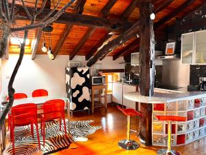une cuisine avec des chaises rouges et un comptoir avec une table dans l'établissement BILBO Near ático rural con terraza, à Basauri