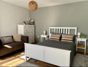 a bedroom with a white bed and a couch at Sudic Villa in Snagov