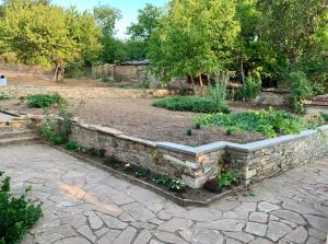 a garden with a stone wall and some plants at Sudic Villa in Snagov