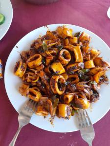 a plate of food on a table with a fork at Lishan Nature Resort - Kataragama in Gotamegama