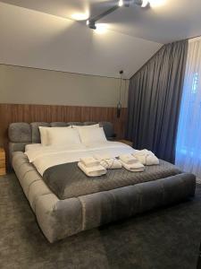 1 dormitorio con 1 cama grande y 2 toallas. en Gloria Hotel by YOLO, en Szack