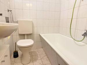 SchalchhamApartment - Nähe Bahnhof - Arbeitsplatz - Badewanne - Piano的带马桶和水槽的白色浴室