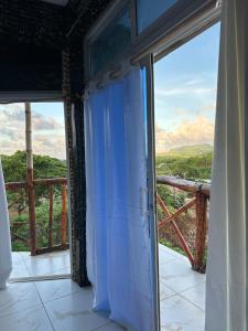 Cette chambre dispose d'une grande porte en verre offrant une vue. dans l'établissement Guest House vista al mar Las Galeras 1, à Las Galeras