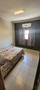 Un dormitorio con una cama y una ventana con cortinas. en Pousada Ilha Sul, en Cananéia