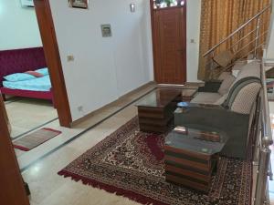 a living room with a stairway with a couch and a rug at Komal Residency in Islamabad