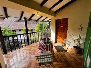 a room with a balcony with a table and chairs at Casa Paqocha Garden - Ollantaytambo - Hot Water - Wifi - Cocina Compartida in Ollantaytambo