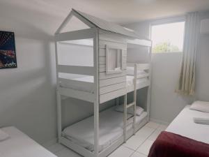 Ein weißes Zimmer mit einem Etagenbett und einem Regal in der Unterkunft FLATS CAMPINA GRANDE - BSH FLATS - Melhor custo benefício in Campina Grande + 63 Fotos