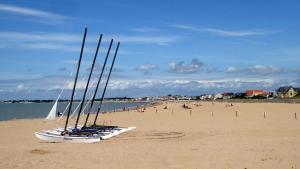 Deux bateaux sur une plage avec des personnes en arrière-plan dans l'établissement Maisonnette avec terrasse et parking, à Châtelaillon-Plage