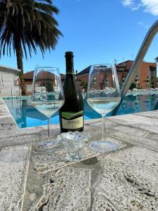 una bottiglia di vino e due bicchieri di vino su un tavolo di Al Borgo Village a Pietra Ligure Altre 11 foto