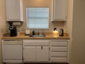 una cucina con mobili bianchi, un lavandino e una finestra di Private First-Floor Guest Suite with 2BR 1Bath full Kitchen a Tracy