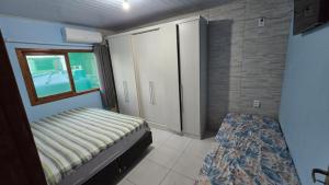 Un dormitorio pequeño con una cama y una ventana. en Refúgio do Pontal, en Palhoça