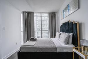 a bedroom with a bed with a large window at Downtown Toronto luxury condos in Toronto