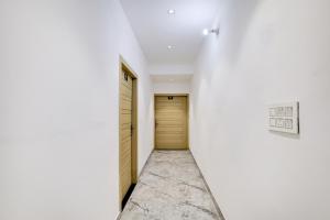 MohaliTownhouse Mohali Bus Terminal Formerly Hotel Hm Crystal的走廊上设有门和白色墙壁