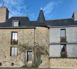 an old stone building with windows and a tower at Chambre d'hôtes dans maison de charme in La Gravelle