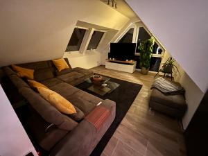a living room with a couch and a television at Luxuriöse Maisonette Wohnung mit Whirlpool und Weitblick im Kurviertel von Bad Salzuflen in Bad Salzuflen