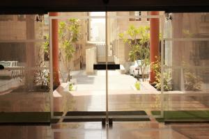 szklane drzwi budynku z roślinami w obiekcie Le Park Hotel w mieście Doha