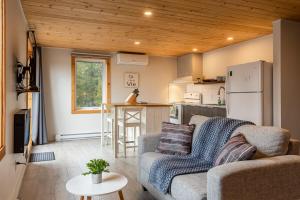 ein Wohnzimmer mit Couch und Küche in der Unterkunft La Sagesse loft 201 balcon privé et vue in Sainte-Lucie-de-Doncaster + 25 Fotos