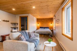 ein Wohnzimmer mit einer Couch und einem Bett in der Unterkunft La Sagesse loft 201 balcon privé et vue in Sainte-Lucie-de-Doncaster