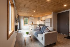 ein Wohnzimmer mit Couch und Küche in der Unterkunft La Sagesse loft 201 balcon privé et vue in Sainte-Lucie-de-Doncaster