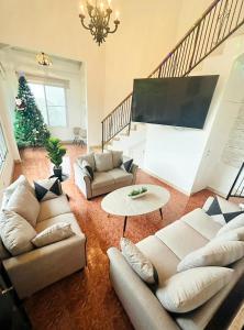 un soggiorno con divani e un albero di Natale di Villa Paraiso de Montana en Altos del Maria a Sorá