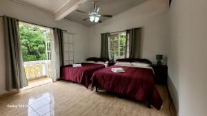 due letti in una stanza con due finestre di Villa Paraiso de Montana en Altos del Maria a Sorá