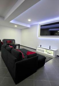 卡列塔Rodrigues House - Private Jacuzzi的客厅配有黑色沙发和平面电视。