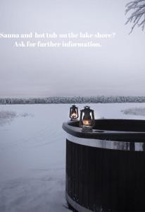 uma banheira de hidromassagem na margem do lago com duas luzes em Raanu Apartments em Raanujärvi