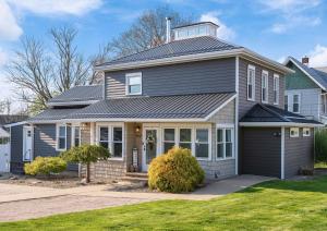 a house with a gray roof and a garage at Luxurious 1875 centrally located Canton Akron home, large primary BR & sunset view in Uniontown