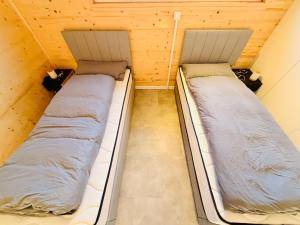 FreestにあるTiny House 3 Küstenlichtの木製の壁の部屋にベッドが2つある +12枚の写真