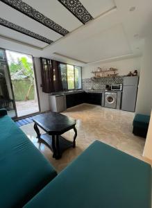a living room with a table and a kitchen at Garden view double room in Agadir