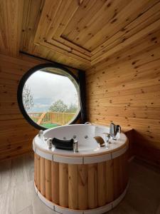 ArdeşenにあるElite Bungalovの丸い窓のある木造の部屋にある浴槽 +7枚の写真