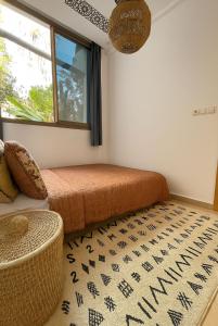 a bedroom with a bed and a window and a rug at Garden view double room in Agadir +9 photos