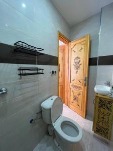 Garden view double room في أغادير: حمام مع مرحاض ومغسلة وباب