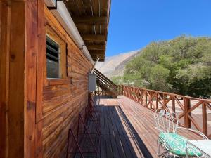 a wooden deck with chairs on the side of a house at Hostal Casa Rosada, Vicuña, Valle del Elqui in Rivadavia